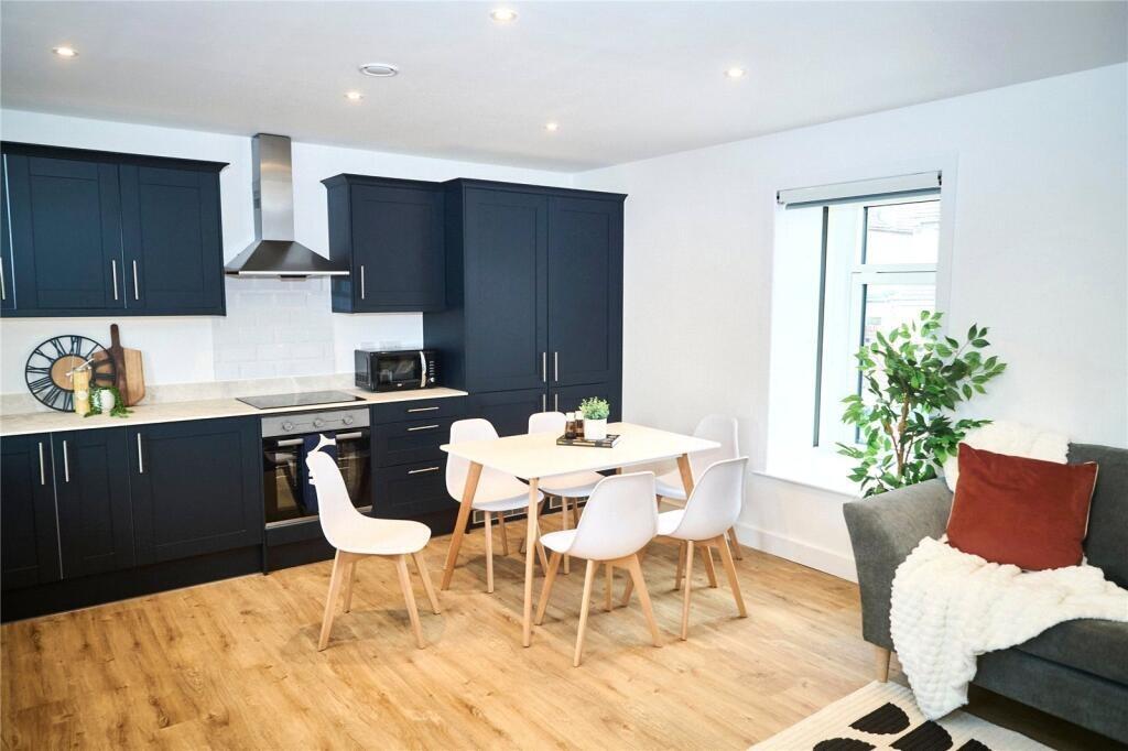 A modern kitchen with sleek black cabinetry and...