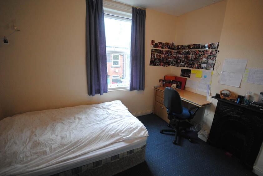 A cozy student bedroom featuring a single bed, ...