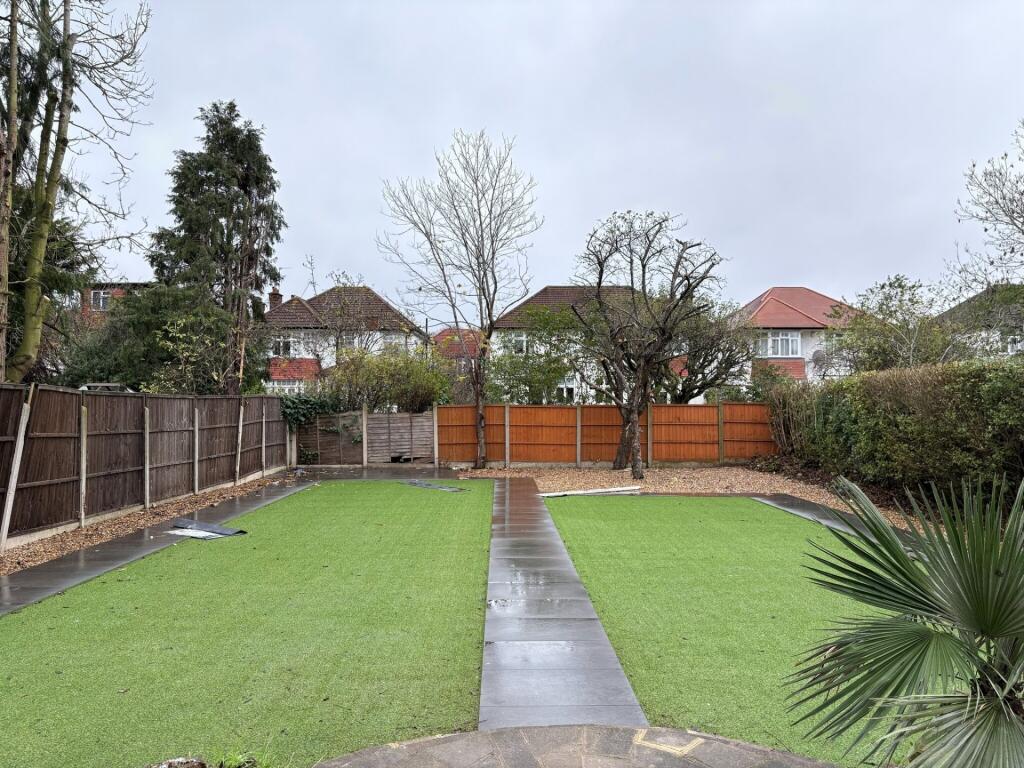 Well-kept rear garden with a central paved path...