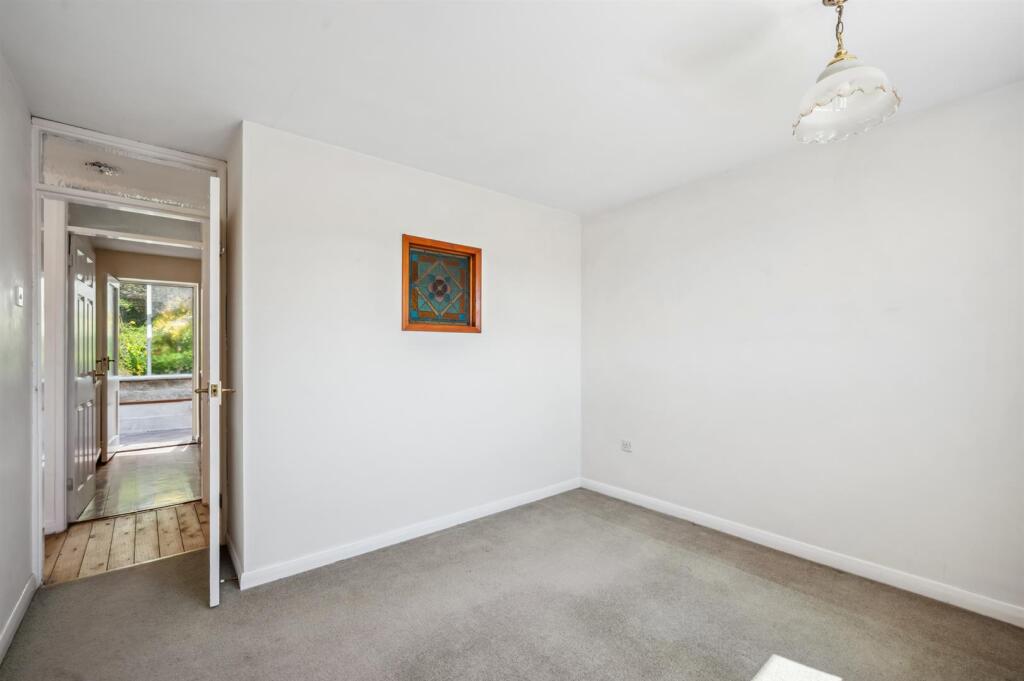 Bedroom Three to kitchen and stained glass window.