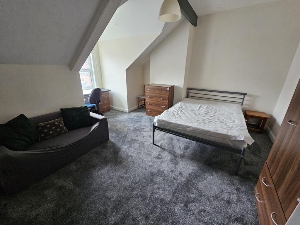 A cozy bedroom with a large window providing na...