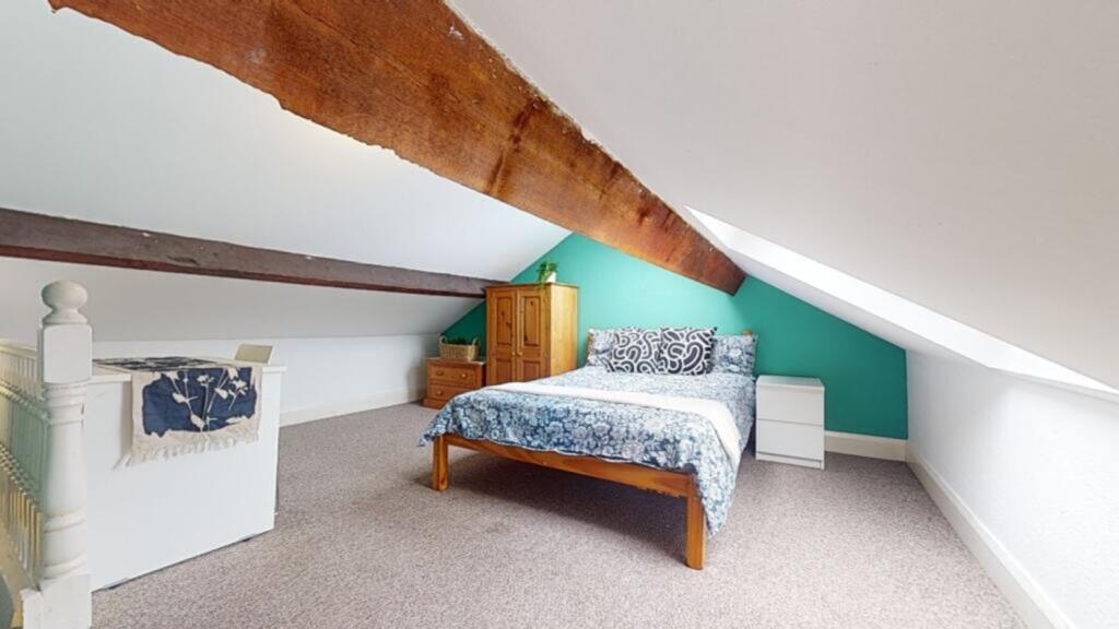 Spacious double bedroom featuring a cozy bed an...