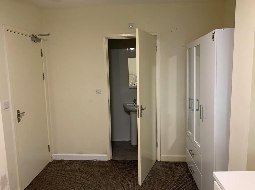 A simple and functional room featuring a door l...