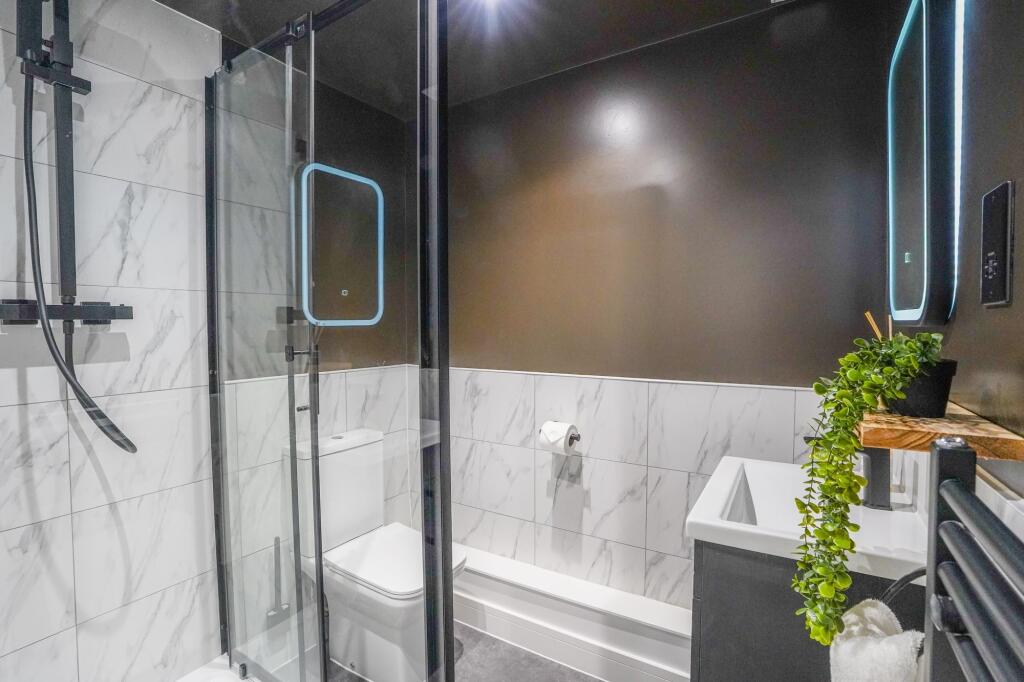 Modern and stylish bathroom featuring a glass-e...