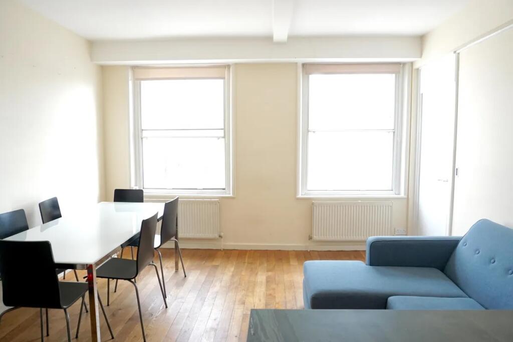 Bright and airy living room featuring two large...