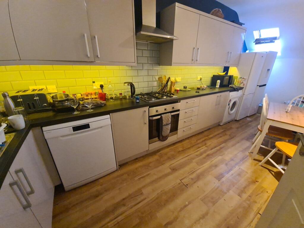 A modern kitchen featuring a long black counter...