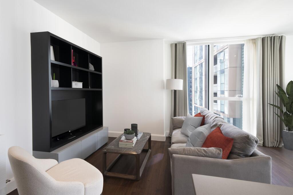 Experience urban elegance in this contemporary living room with ample natural light.