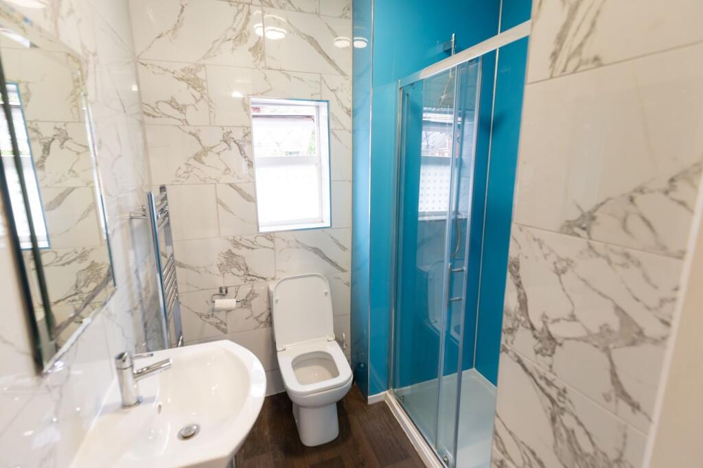 Modern bathroom featuring elegant marble-effect...