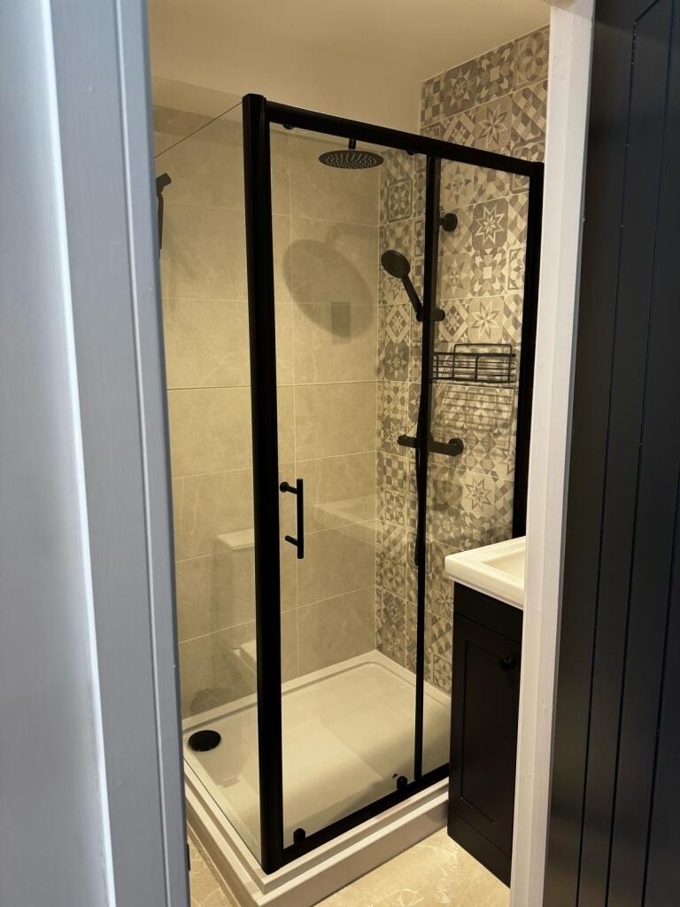 A modern bathroom featuring a stylish walk-in s...