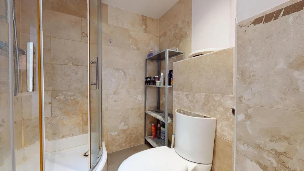 A modern bathroom featuring a curved glass show...