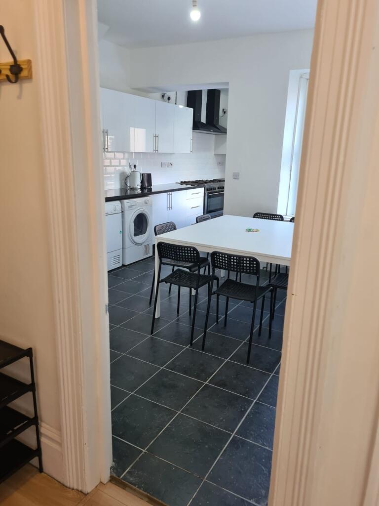 A modern kitchen featuring sleek white cabinets...