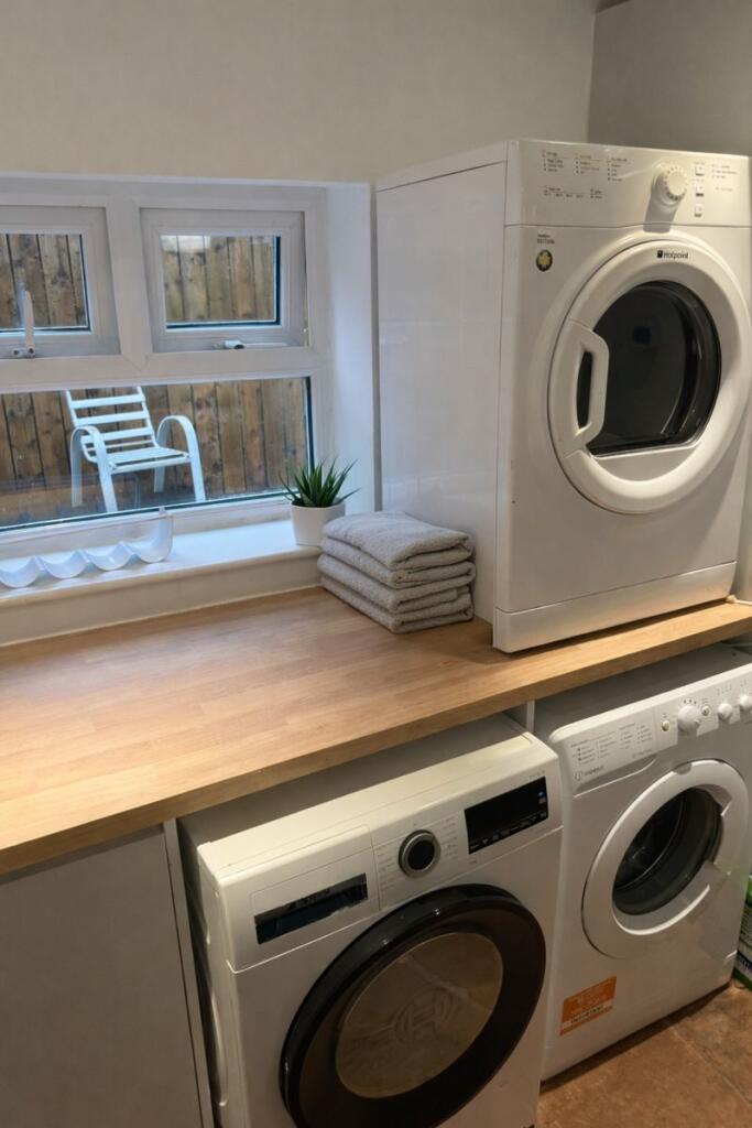 Bright, well-organised utility room with stacke...