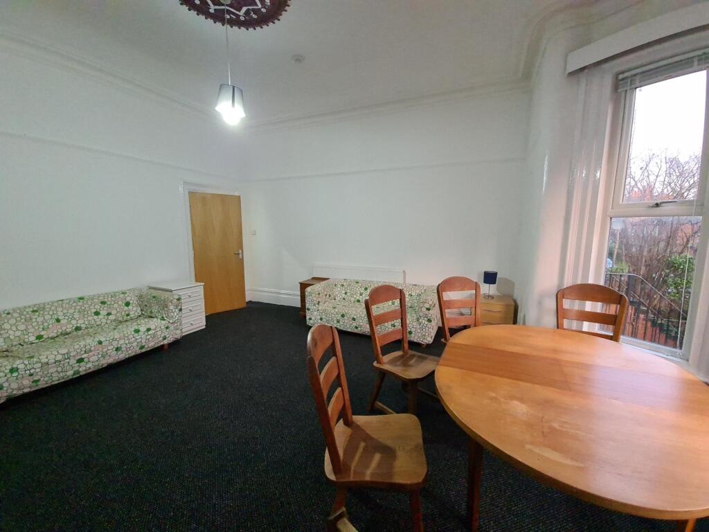 A spacious and well-lit living room with seatin...