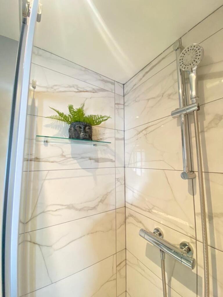 A modern bathroom featuring a stylish shower wi...