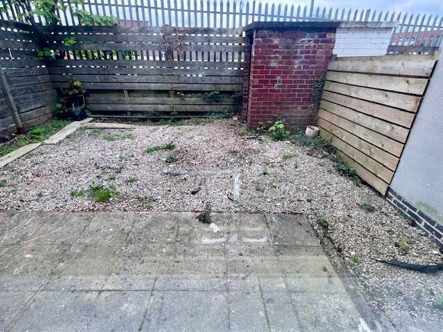 A small enclosed garden space with a paved pati...