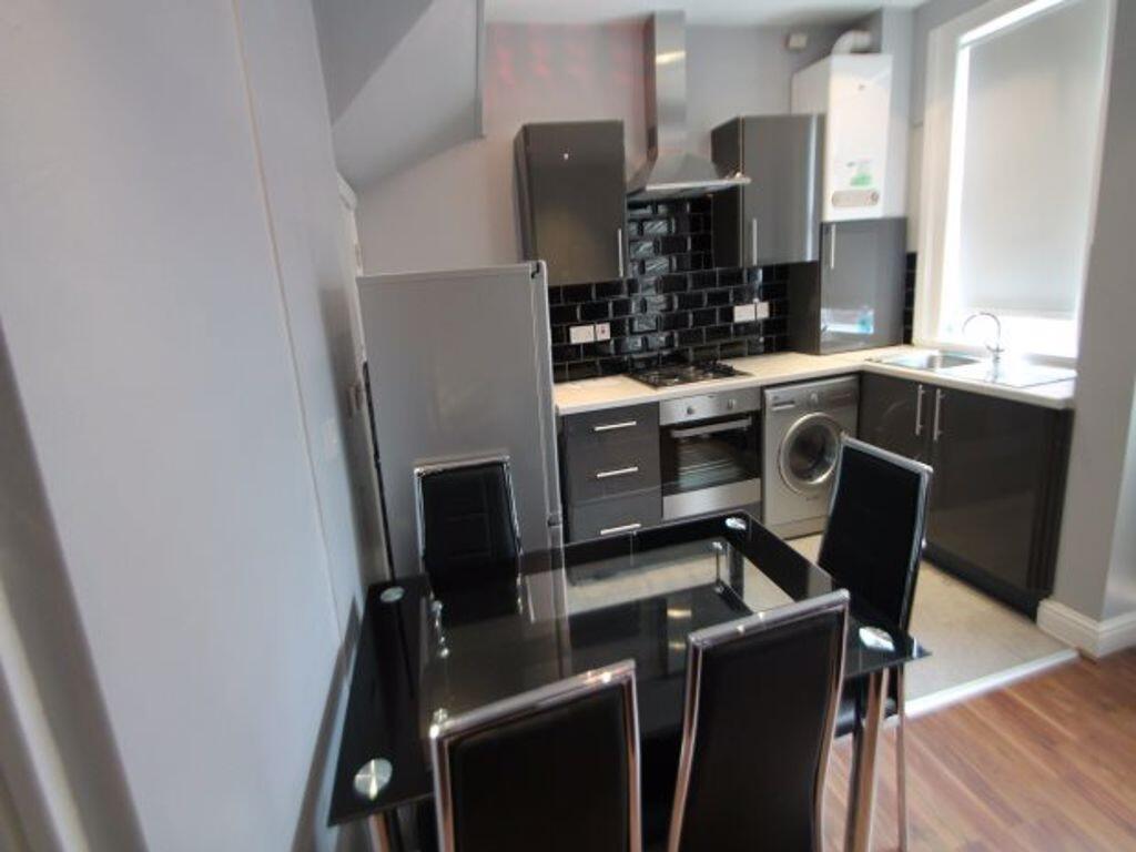 Modern kitchen featuring sleek black and grey c...