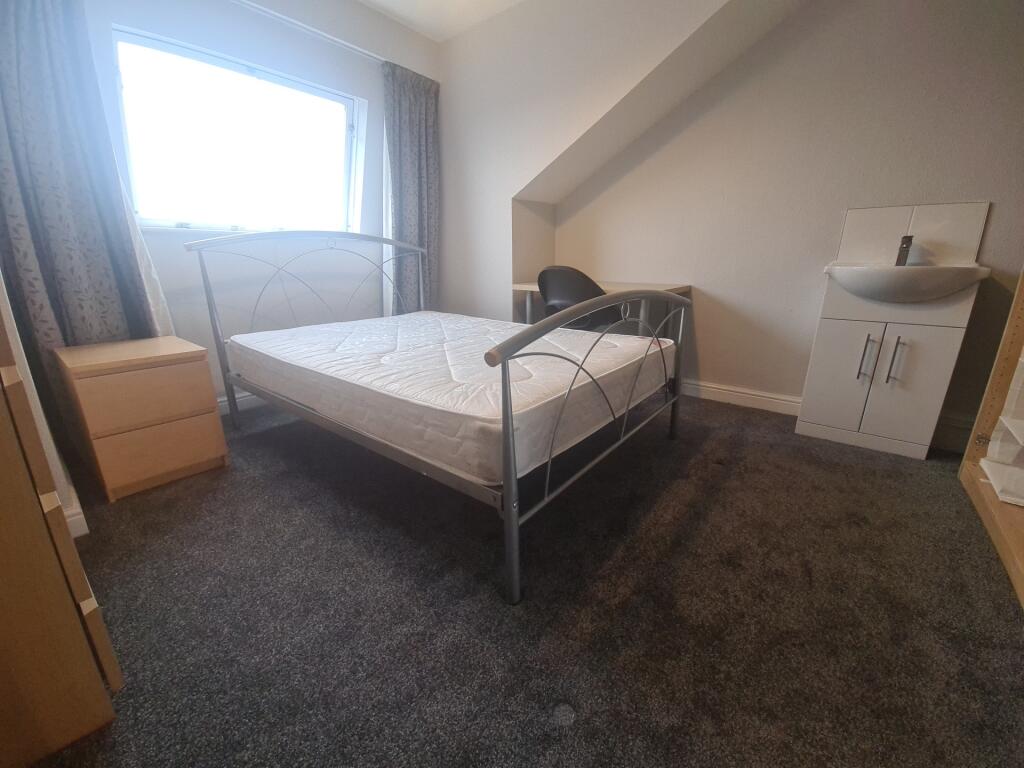 A tidy single bedroom featuring a metal bed fra...