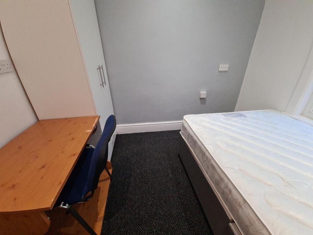 A tidy and welcoming bedroom featuring a comfor...