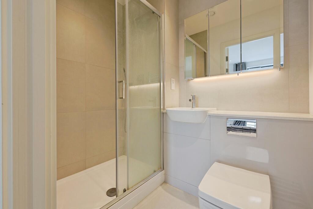 A modern, clean bathroom featuring a shower enc...