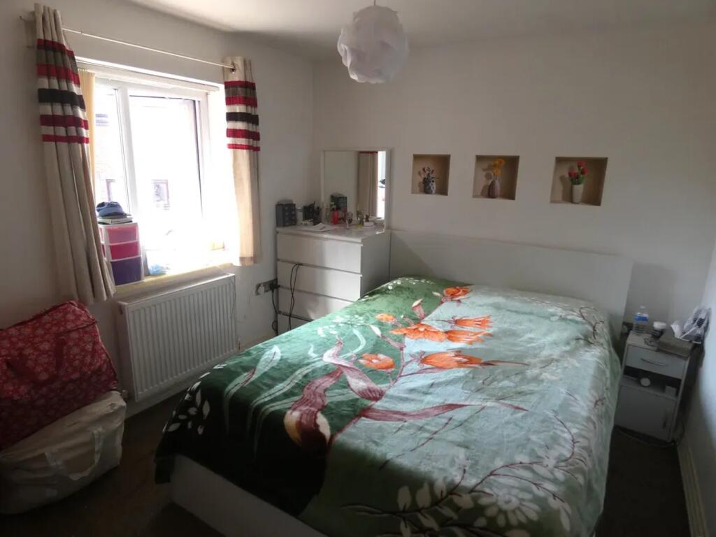 A cozy double bedroom featuring a vibrant flora...