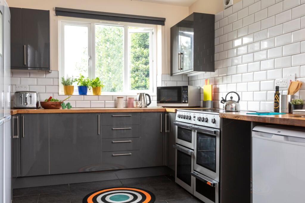 Modern kitchen featuring a large window bringin...