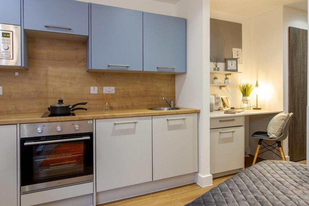 A modern and tidy kitchen area with wood-effect...