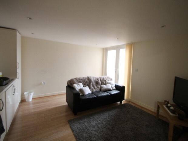 A bright and spacious living room featuring a c...