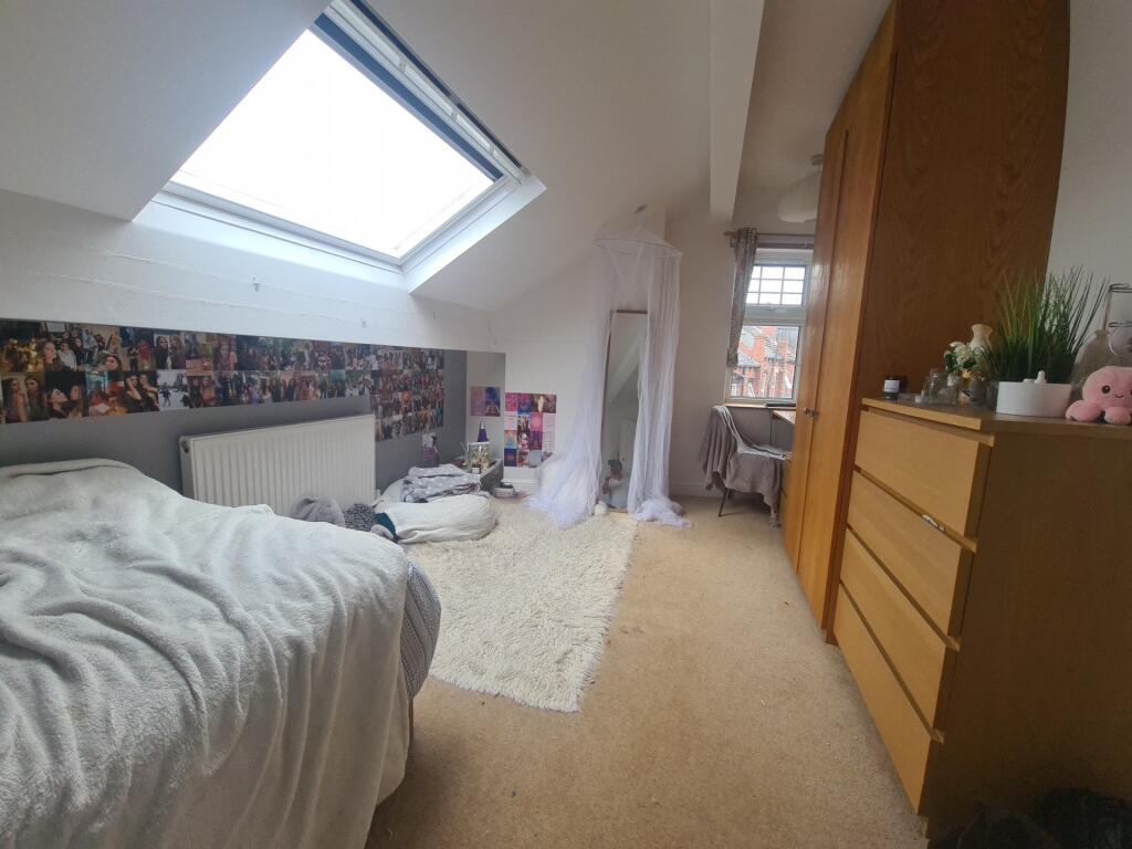 A cozy single bedroom featuring a comfortable b...