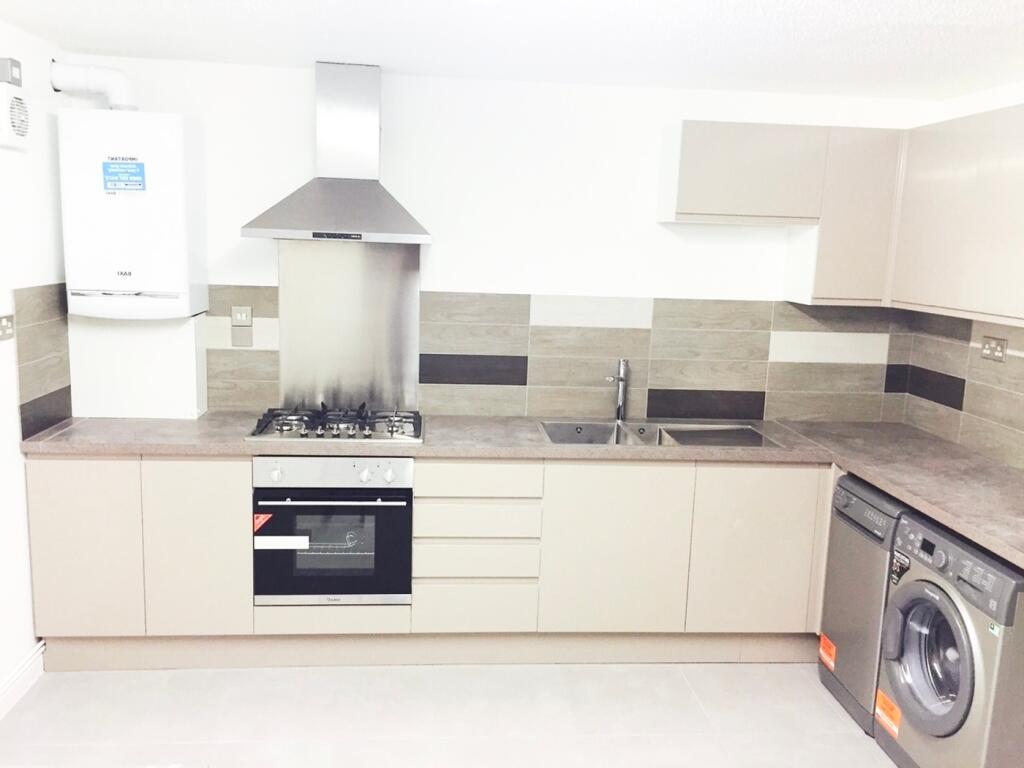 Modern kitchen featuring sleek cabinetry, ample...