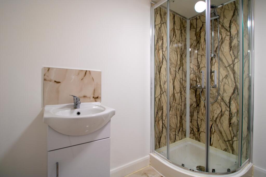 Modern and clean bathroom with a glass-enclosed...