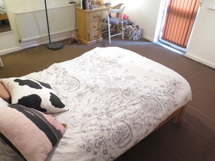 A spacious double bedroom featuring a neatly ma...