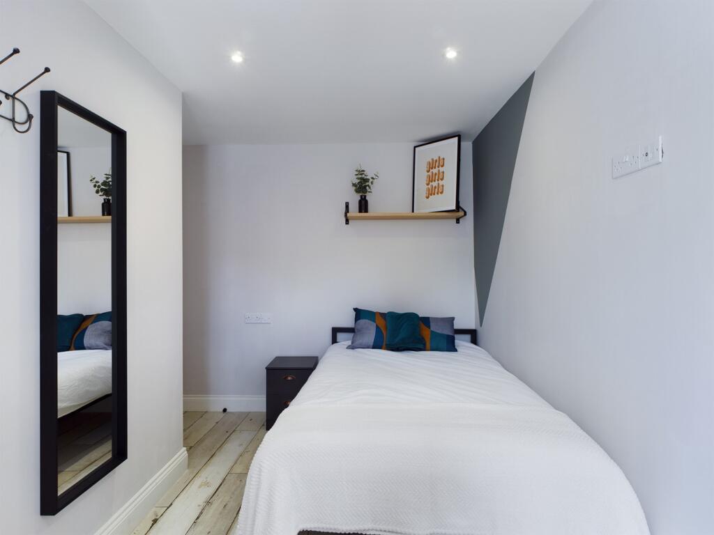 A bright and tidy single bedroom with modern de...