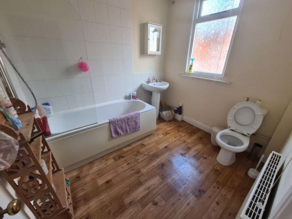 A bright and tidy bathroom with a large bathtub...