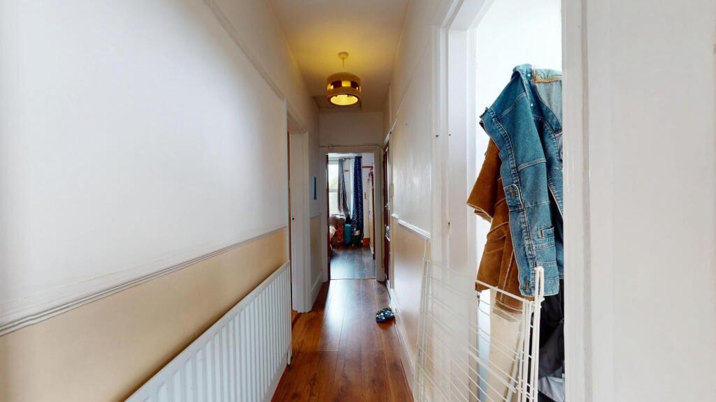A clean and well-maintained hallway with wooden...