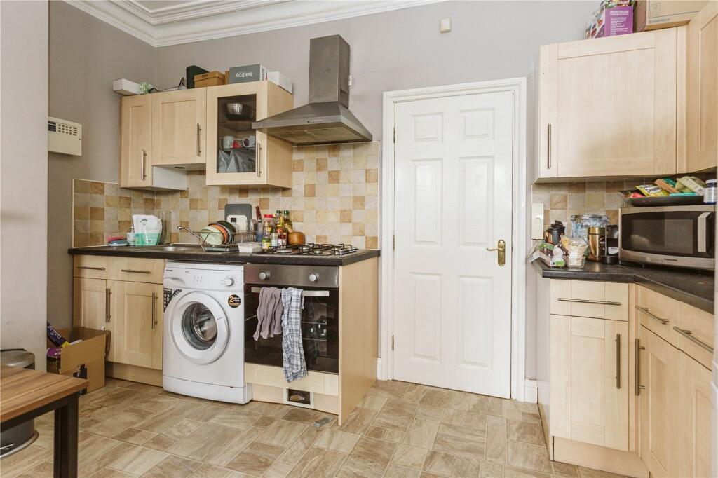 A well-equipped kitchen featuring modern wooden...