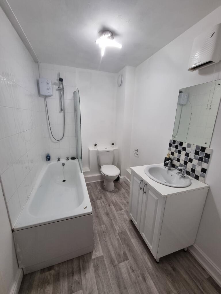 Bright and clean bathroom featuring a bathtub, ...