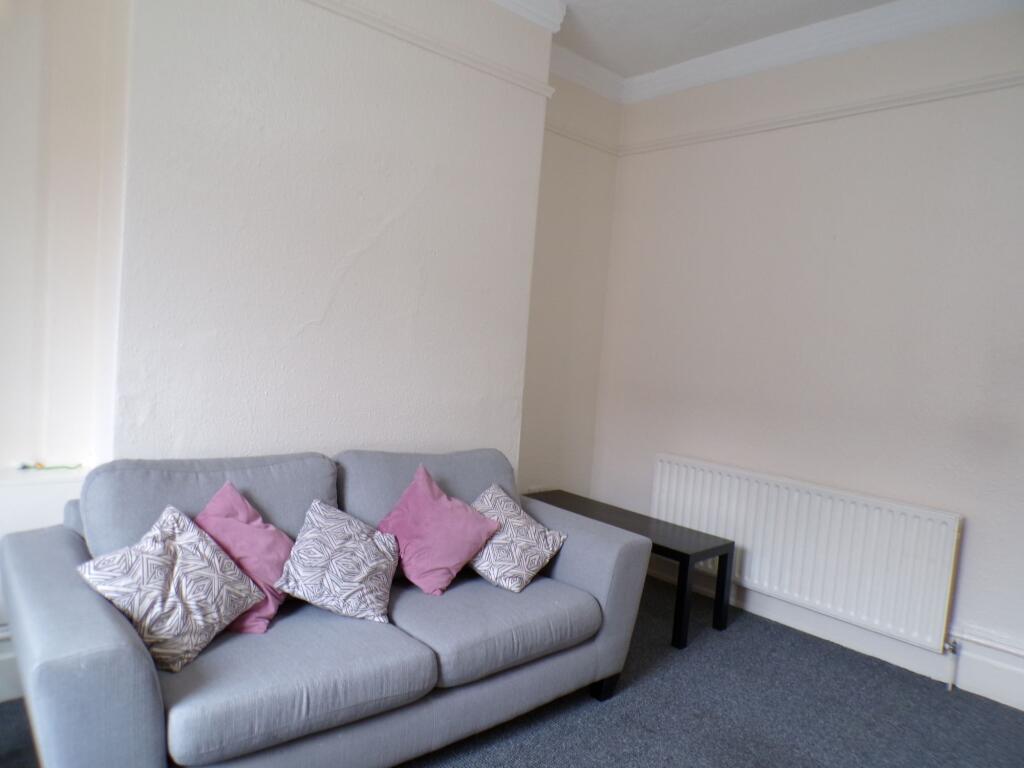 A spacious living room featuring a comfortable ...