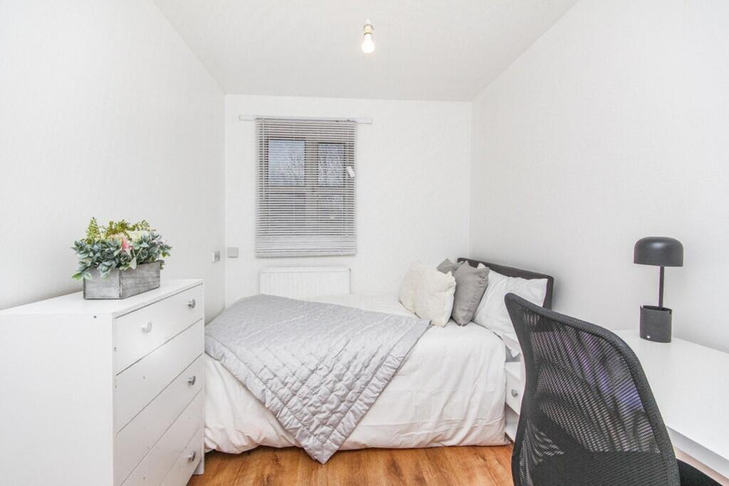 This cozy double bedroom features a comfortable...