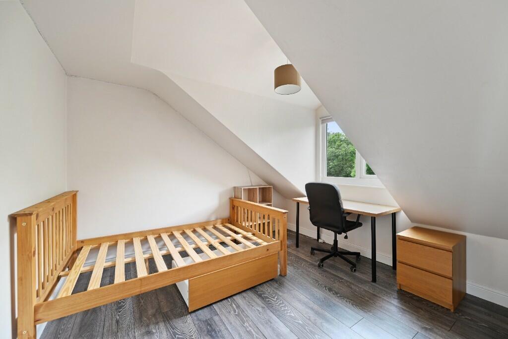 A bright and tidy single bedroom featuring a wo...