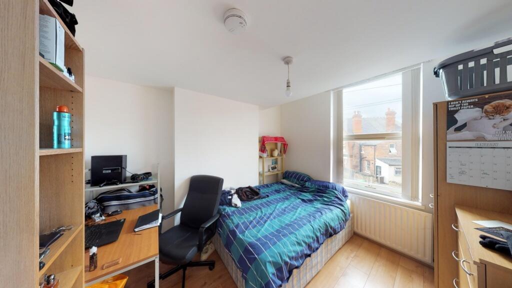 A cozy, well-lit bedroom featuring a comfortabl...