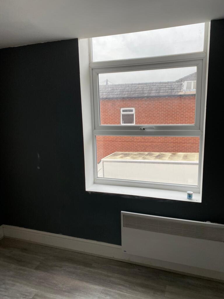 A cozy bedroom featuring a large window with am...