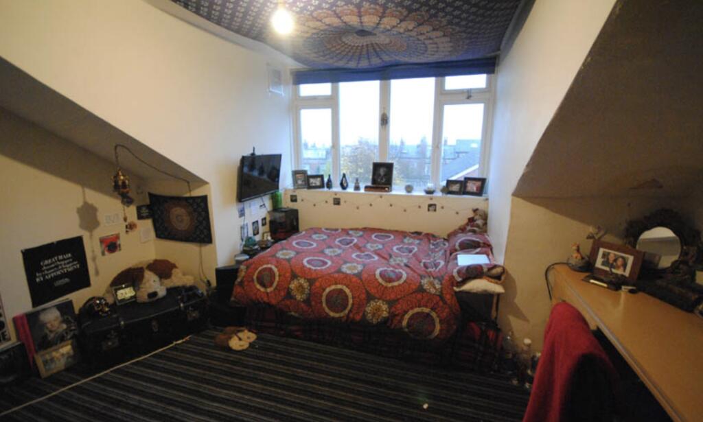 A cozy single bedroom with a comfortable bed, a...