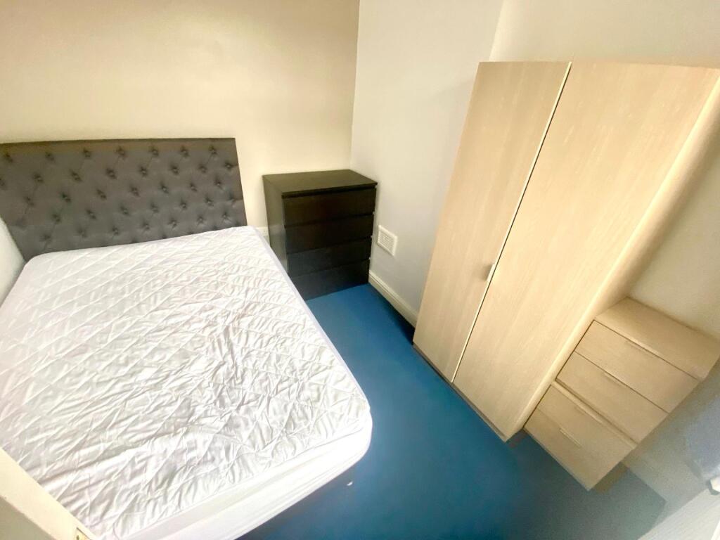 A simple, bright single bedroom featuring a com...