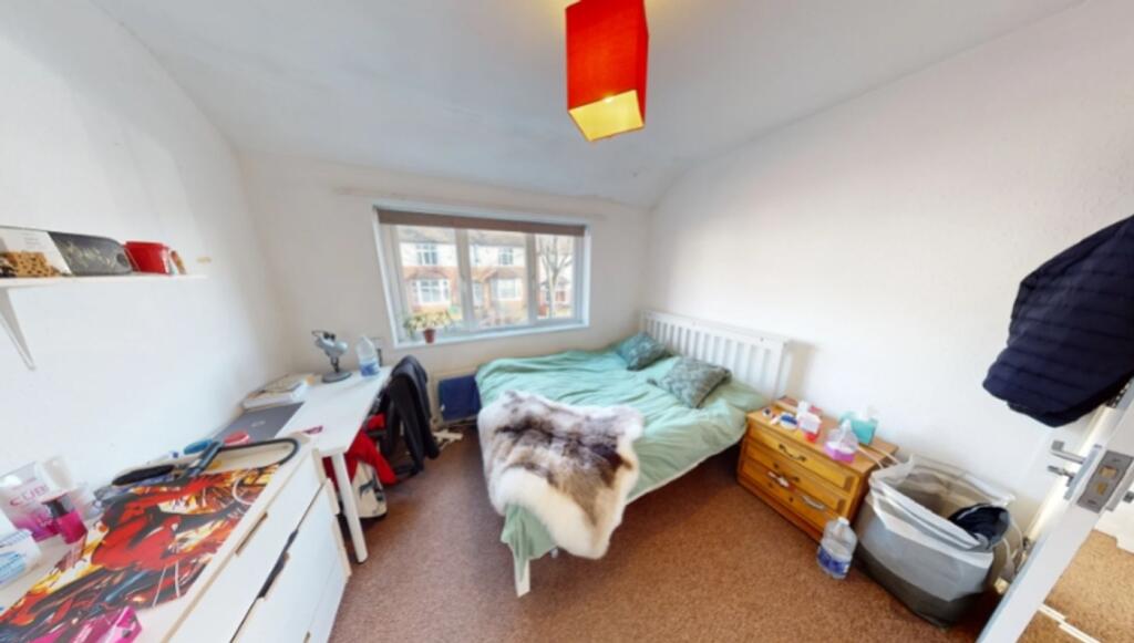 A bright and inviting double bedroom with a coz...