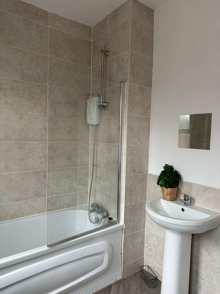 A clean and modern bathroom featuring a bathtub...