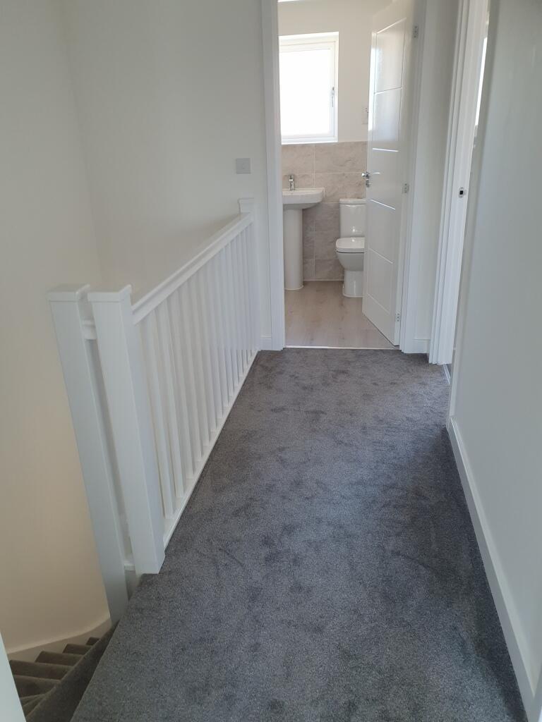 A bright and well-maintained hallway featuring ...