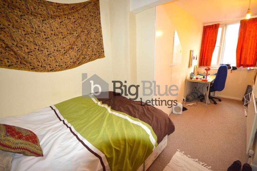 Cozy single bedroom featuring a neatly made bed...