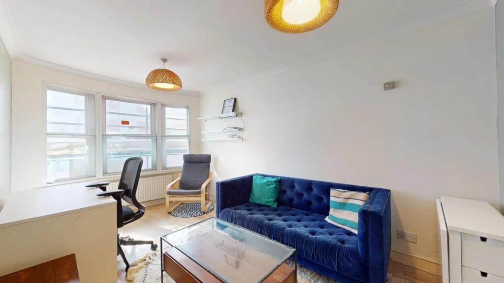 Bright living room featuring a stylish deep blu...