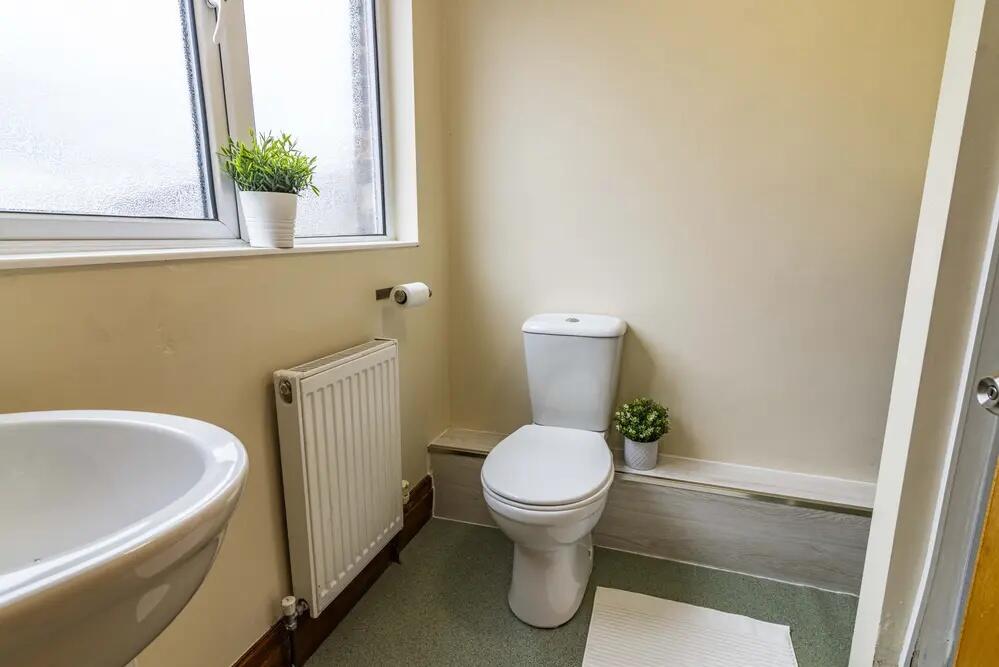 Bright and tidy bathroom featuring a white toil...