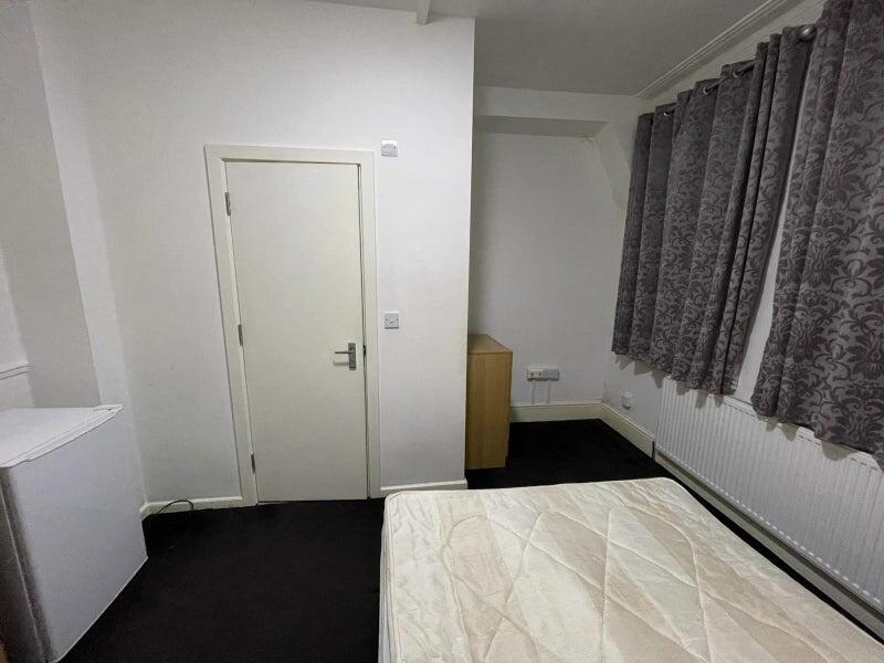 Simple, tidy bedroom with a large window dresse...